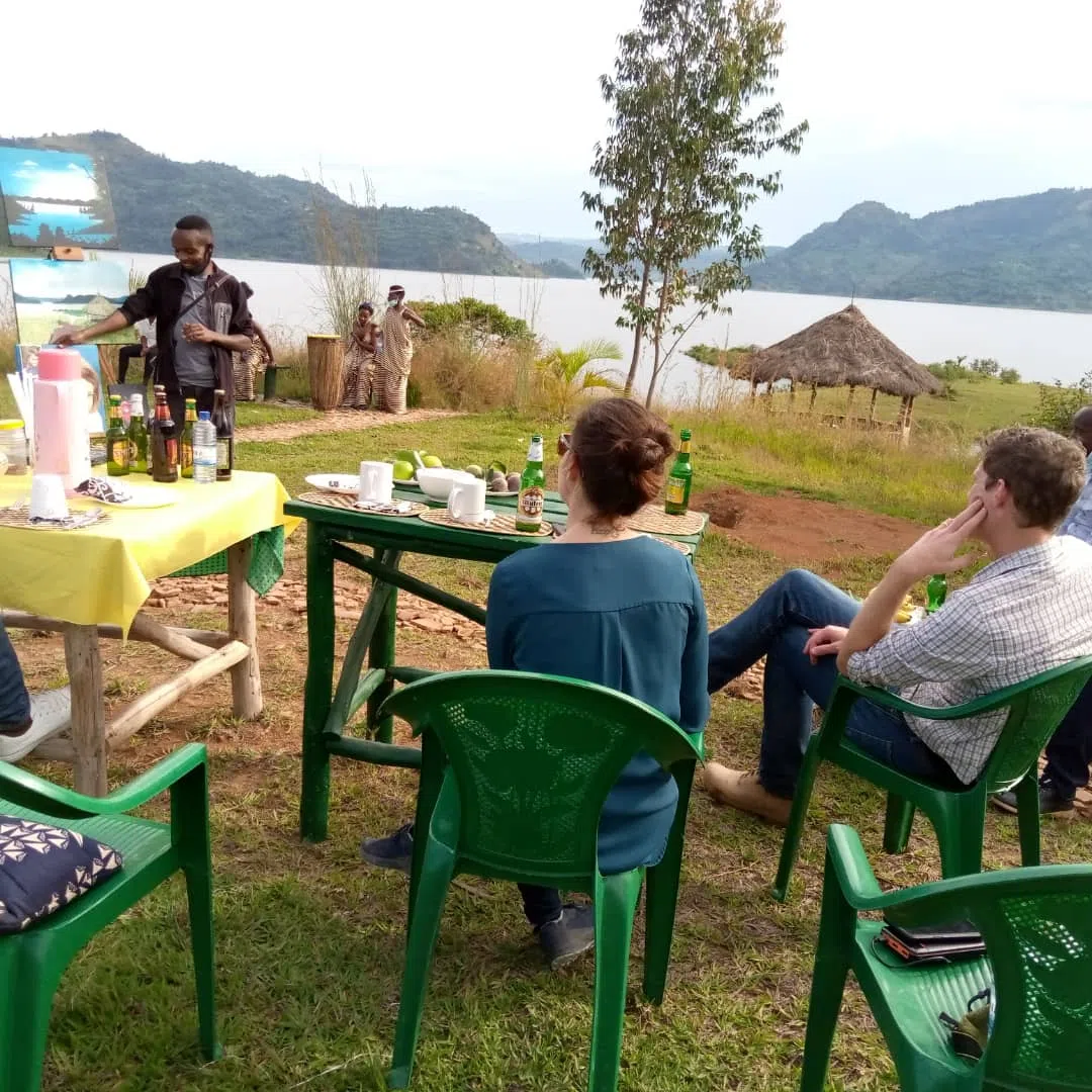 a group of tourists enjoying an outdoor
              meal in the rwandan countryside