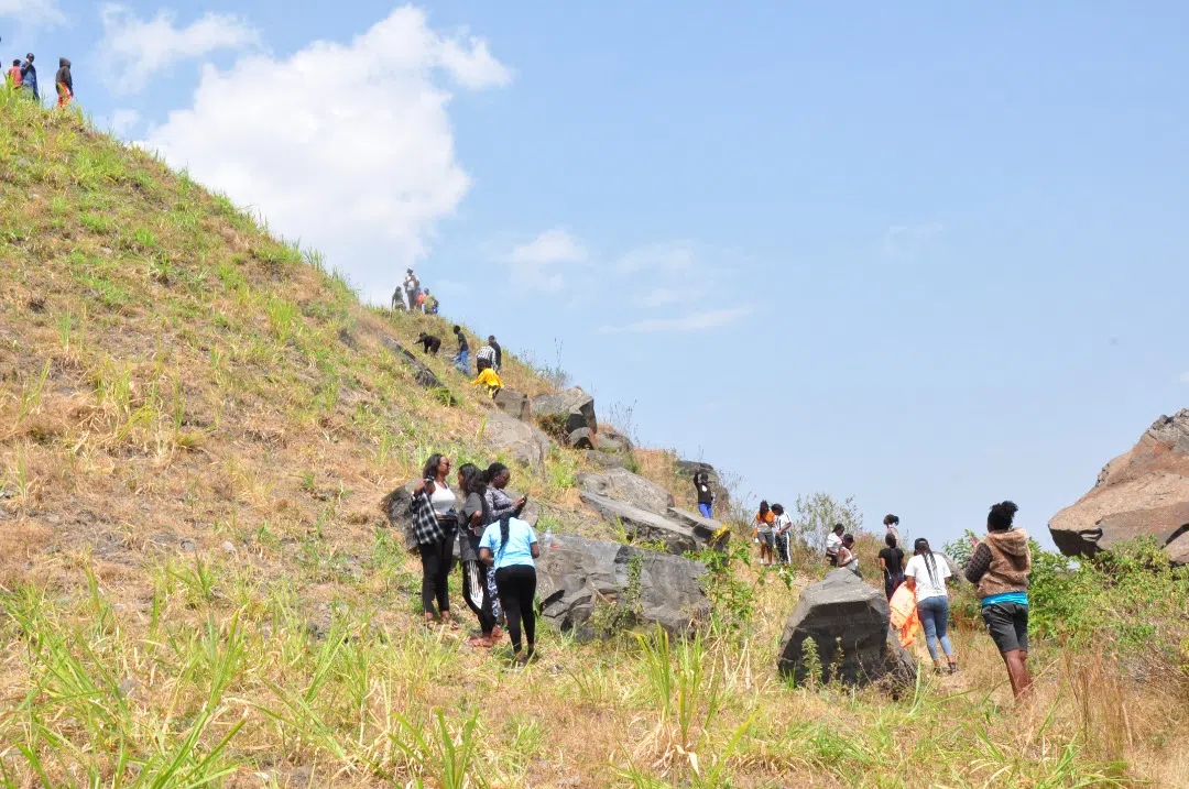 Tourists going up a mountain. It's sunny and there are clear skyes